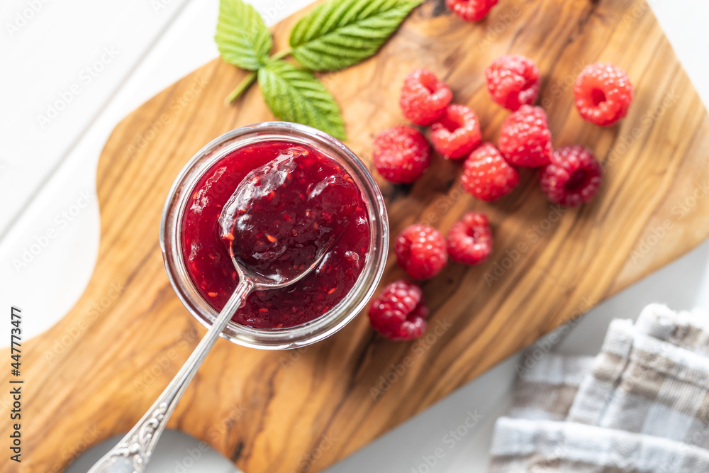 Wall mural red rasberries jam in jar and ripe raspberries.