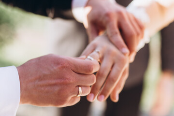 Wedding rings in the hands of the bride and groom.