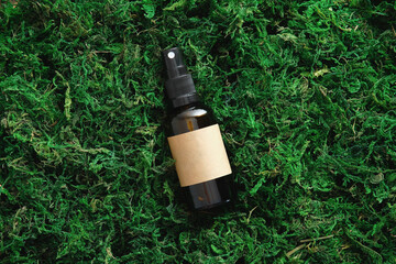 Amber glass cosmetic container on moss background in forest. Natural eco-friendly beauty product branding, packaging design.