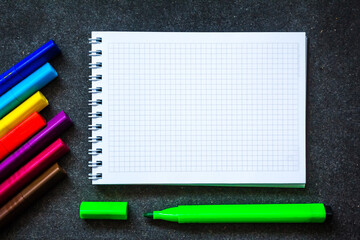 back to school. School suppliesagainst the background of a dark board . Copy space .