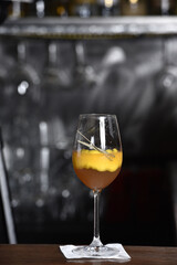 refreshing alcoholic drink with berries, ice vodka and gin, lemon peel served in glass cup on the counter on blurred background
