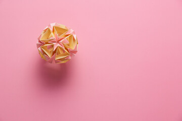 Multicolor handmade modular origami ball or Kusudama Isolated on pink background. Visual art,...