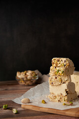 Organic halva with pistachios on a wooden surface. Traditional middle eastern sweets. Jewish,...