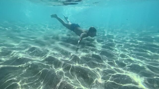 child waves his hand underwater