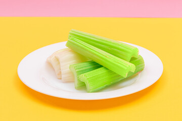 Fresh Chopped Celery Sticks on White Dish. Vegan and Vegetarian Culture. Raw Food. Healthy Diet with Negative Calorie Content