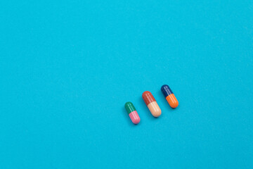 Global Pharmaceutical Industry and Medicinal Products - Colored Pills or Capsules Scattered on Blue Background