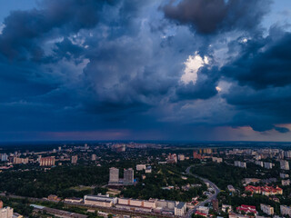 Aerial view on rain clouds at sunset over the city