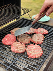Homemade hamburgers cooking on barbeque grill