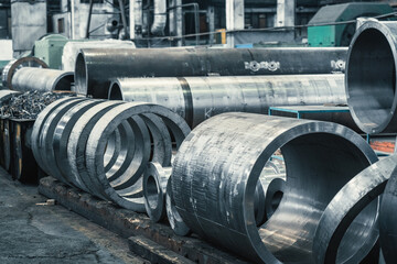Large round metal pipes in factory workshop. Pipeline or steel tube production for heavy industry.