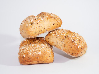Baked bun soaked in sesame seeds and oatmeal isolated on white background. 