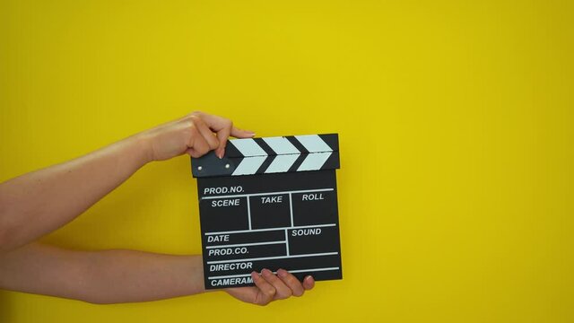 Hands using a film clapper board, close up. Clapped on and off. 4K video footage.