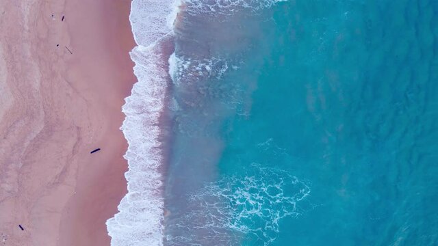 4K. Scene of Top-down drone view shot. on the Andaman coast. Beautiful seawater wave texture on beach The sea and large ripples that wash against the shore are filled with beautiful soft white sponges