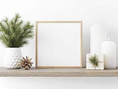 Square wooden frame mockup with pine branch in vase, pinecone, candles and gift box on rustic rough shelf on white wall background. Minimal Christmas interior decoration. 3d rendering, illustration