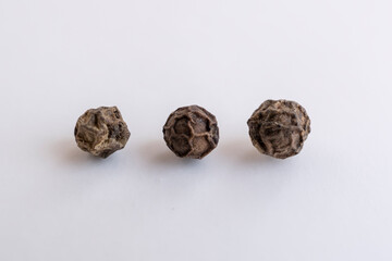 tres granos de pimienta negra entera macro