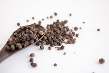 cuchara con especia de bolitas de pimienta negra entera