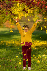 Autumn. Beautiful happy little girl and laughing in autumn park, throws colorful leaves. Teenage Girl Having Fun outdoor. Healthy Lifestyle concept