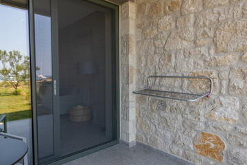 View of outdoor clothes dryer on patio of hotel room. Mosquito net protection on door. Greece. 