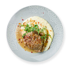 Beef cheeks with mashed potatoes on grey plate isolated on white top view