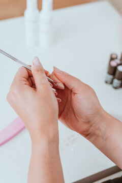 Maniküre der Fingernägel mit Feile. Junge Frau macht schöne Nagelpflege vor Füllung mit Acryl 