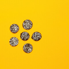 Chocolate cookies on yellow paper background. Minimal art. Holidays time, winter christmas celebration, diet, calorie, sweet shop concept. Flat lay  art