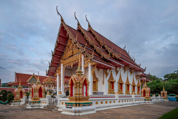 Obraz premium Buddhist temple of red, white and gold tones on the Thai island of Phuket on a summer day with partly cloudy skies