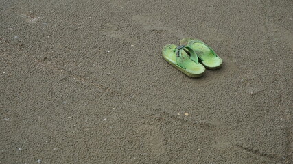 A pair of sandals at the beach