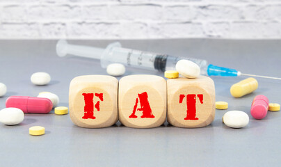 a group of white and red pills and cubes with the word fat on them, white background.