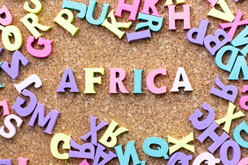 Color alphabet in word africa with another letter as frame on cork board background