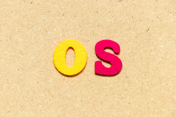Color cloth alphabet letter in word OS (Abbreviation of Operating system) on wood background