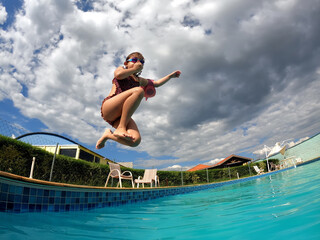 Small girl diving into the pool 