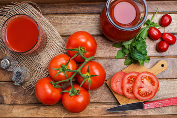 tomato juice in a glass and chopped tomatoes on a cutting board.