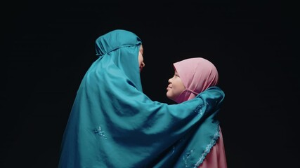 Concept Eid mubarak, Muslim girl, Islamic girl, teasing mother with love and mother watching beautiful hijab at mosque after prayer.