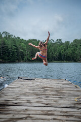 Fototapeta na wymiar Girl Jumping off dock
