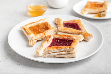 Plate with Danish pastry on light background