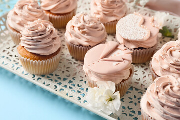 Tray with tasty wedding cupcakes on color background