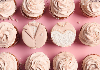 Tasty wedding cupcakes on color background
