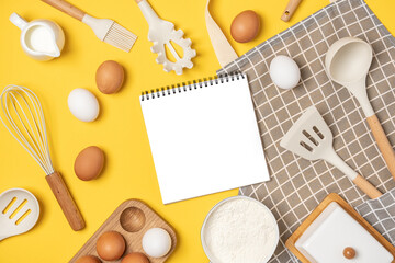 Baking ingredients, cooking utensil and open notebook on yellow background. Template for cooking recipes or your design. Top view Flat lay Mockup