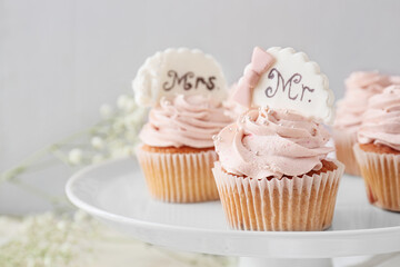 Dessert stand with tasty wedding cupcakes on table
