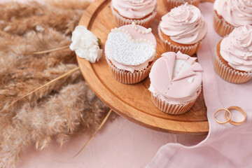 Dessert stand with tasty wedding cupcakes on color background, closeup