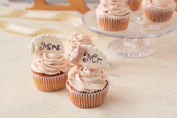 Tasty wedding cupcakes on table