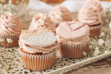 Tray with tasty wedding cupcakes on wooden background