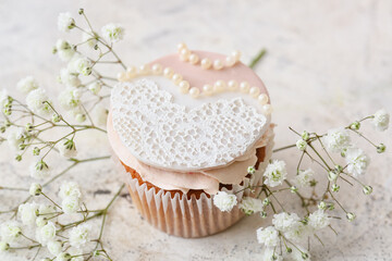 Tasty wedding cupcake on light background