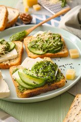 Tasty toasts with pesto sauce on color wooden background, closeup