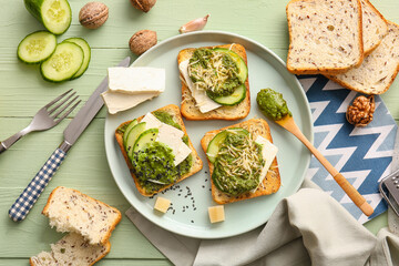 Tasty toasts with pesto sauce on color wooden background