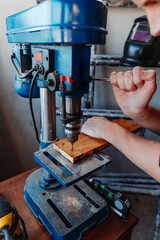 young caucasian carpenter bored with bench drill