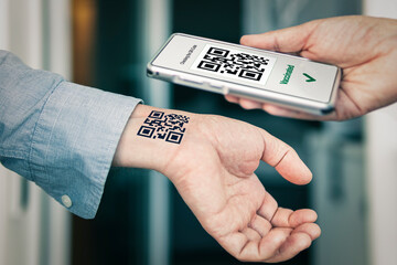 man shows his hand with a qr code, a confirmation of the vaccination against the covid 19...