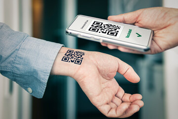 man shows his hand with a qr code, a confirmation of the vaccination against the covid 19 coronavirus. Temporary tattoo. Scan the QR code using the mobile application. Proof vaccination
