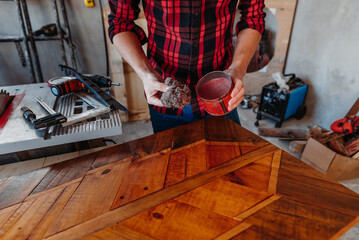 young carpenter waxing wooden box