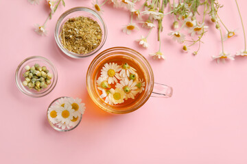 Composition with chamomile tea and dried flowers on color background