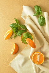 Glass of tasty lemonade with basil on color background